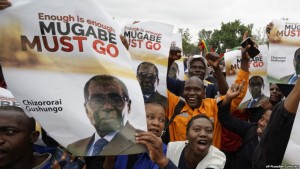 Protesters hold posters asking President Mugabe to step down, on which one has handwritten "37 years for nothing", at a demonstration at Zimbabwe Grounds in Harare, Zimbabwe Saturday, Nov. 18, 2017. Opponents of Mugabe are demonstrating for the ouster of the 93-year-old leader who is virtually powerless and deserted by most of his allies. Writing in Shona on poster refers to Mugabe in a respectful way saying "Go and rest now". (AP Photo/Ben Curtis)